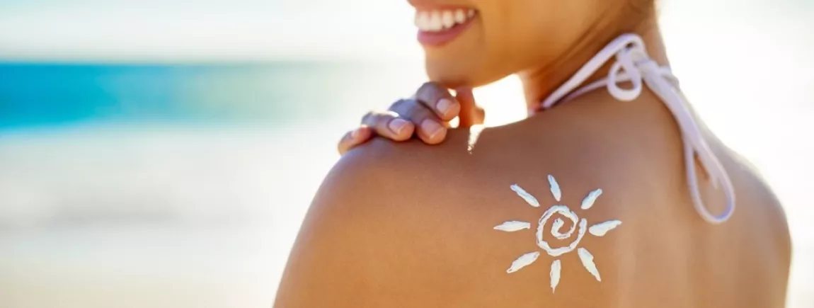 Une femme se passe de la crème solaire dans le dos