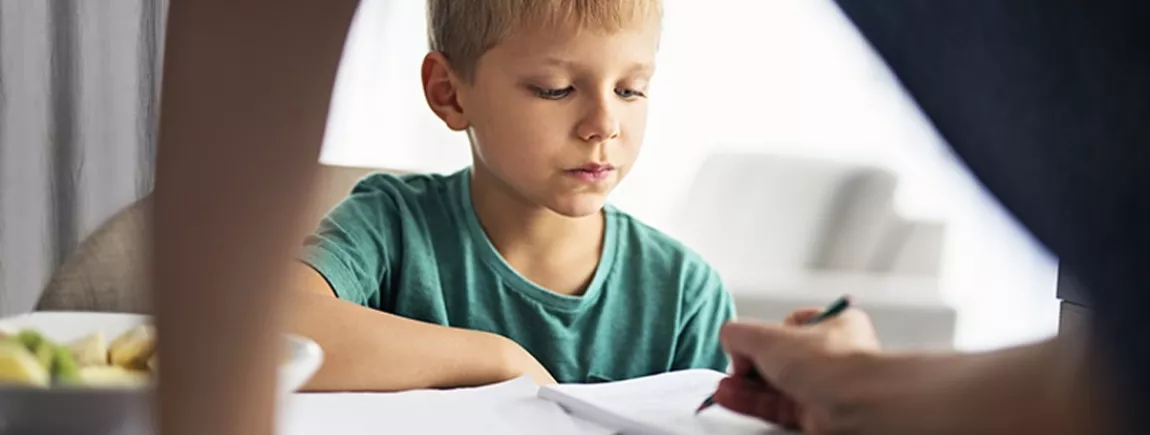 Comment l’aider à faire ses devoirs ? Un petit garçon fait ses devoirs avec sa maman