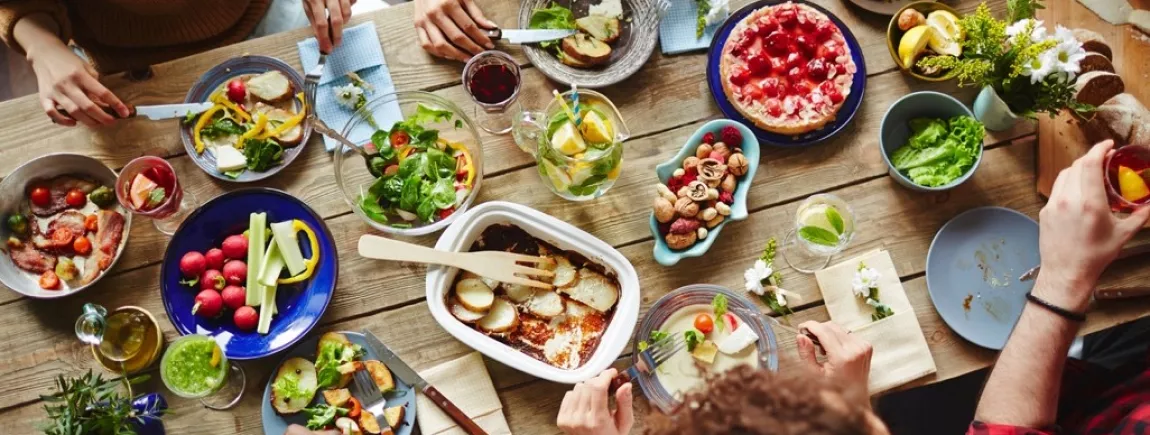 Des amis attablés à une table garnie de produits de saison 