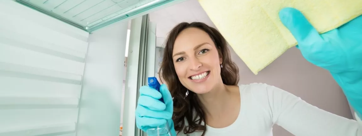 Une femme nettoie l’intérieur de son frigo