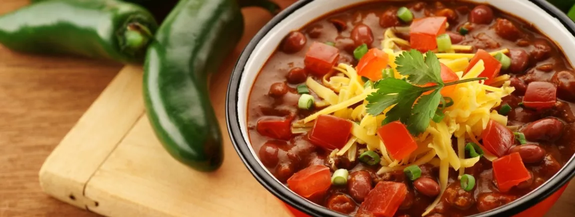 Un plat de chili con carné entouré de légumes