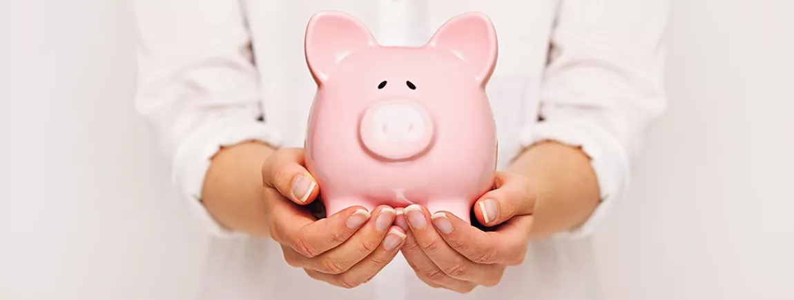 Petit guide pour limiter sa consommation et faire des économies Une tirelire dans les mains d’une femme