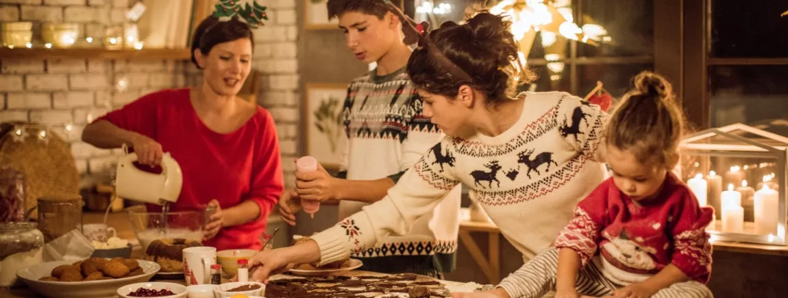 Une famille préparent un repas de noël dans la cuisine