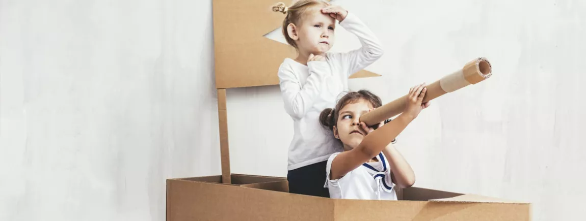 enfants jouant dans un bâteau en carton