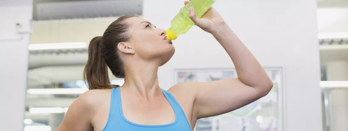 Femme sportive en train de boire pendant sa séance d’exercice pour s'hydrater