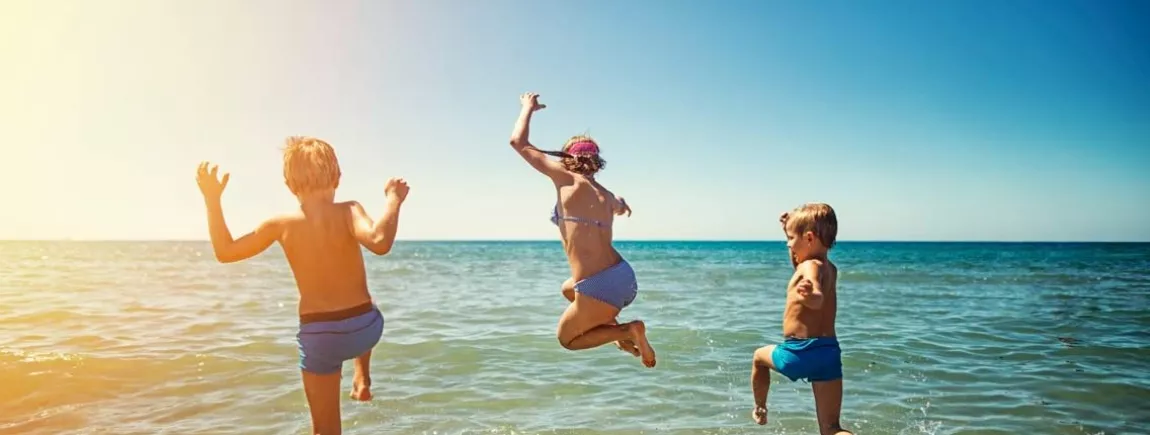 Une famille court sur une plage pour se baigner