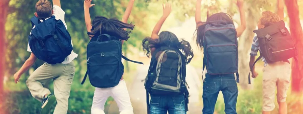 Un groupe d’écoliers exécutent ensemble un saut sur le chemin de l’école