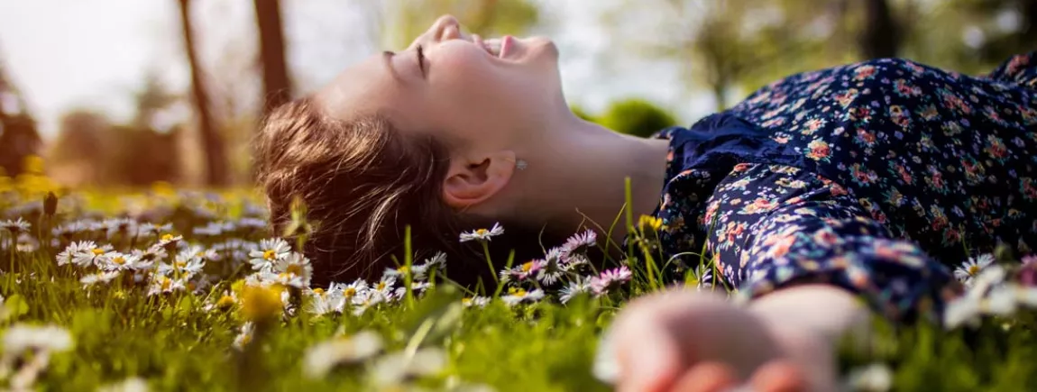 Une femme est allongée dans l’herbe dans un parc.