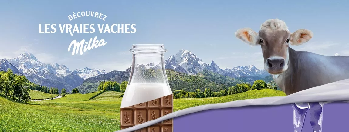Une vache, une bouteille de lait et une tablette de chocolat dans un décor Alpin