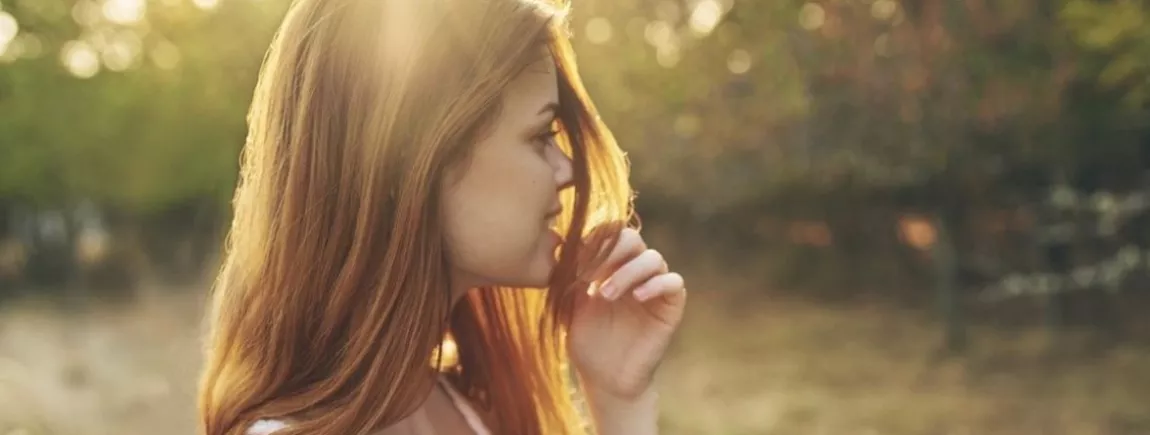 Soin des cheveux. Jeune femme souriante. Nature. Cheveux brillants. 