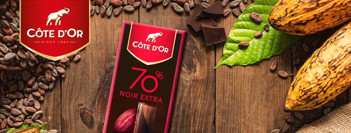 Une tablette de chocolat sur une table avec une fève de cacao.