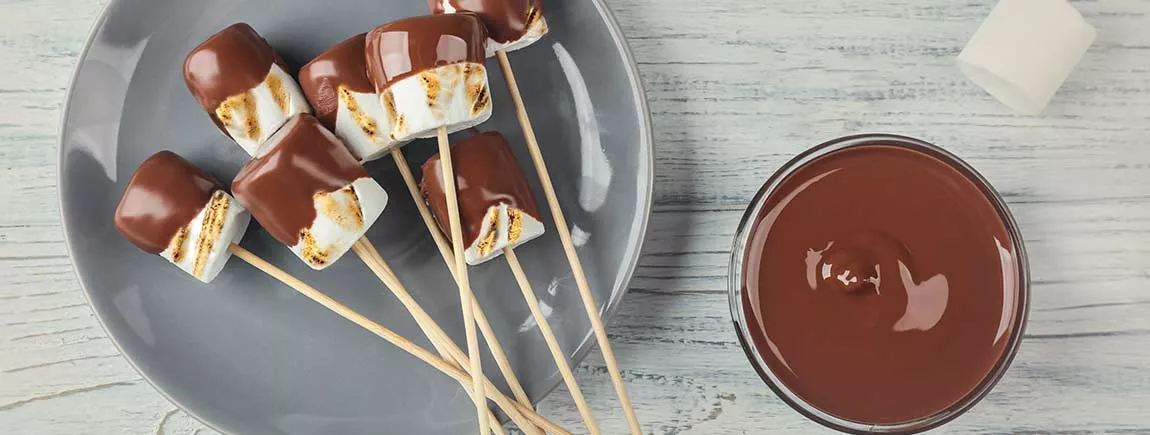 Des brochettes de guimauves grillées au chocolat fondu