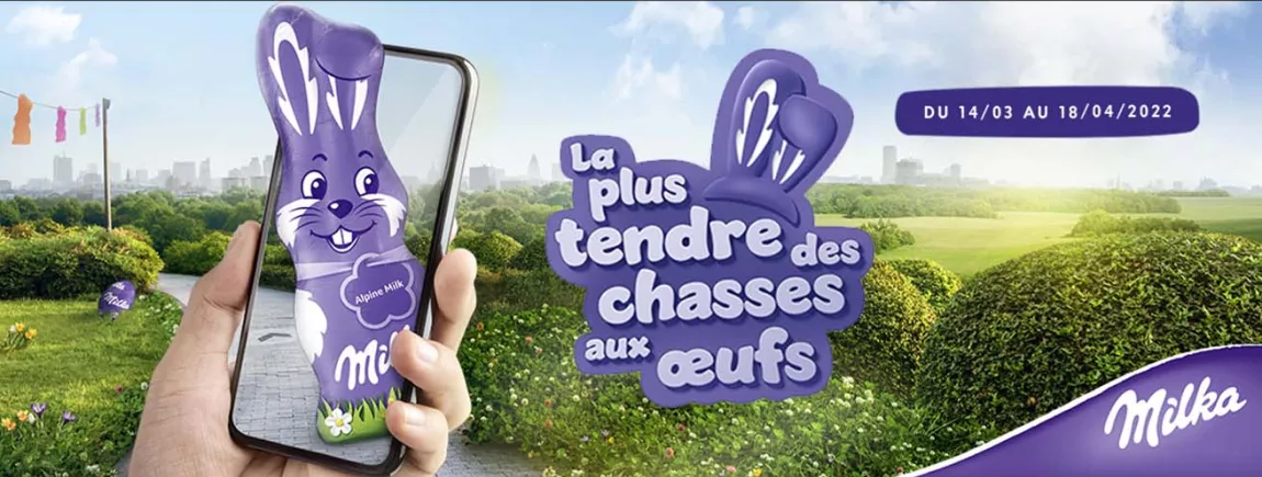 Tentez de gagner des cadeaux et aidez l’association Handicap International ! Sur un fond de jardin, un lapin en chocolat sort d’un téléphone