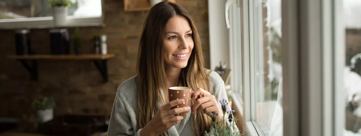 Une femme avec une tasse dans les mains