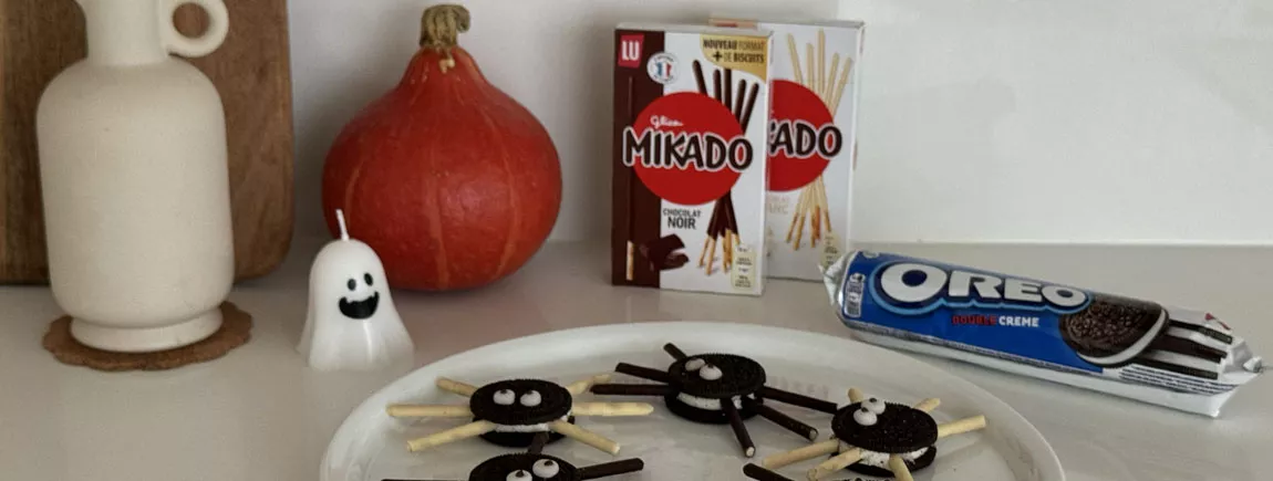 Recette Araignées Oreo-Mikado Les araignées en Oreo et Mikado dans une assiette avec des packs d'Oreo et de Mikado en fond