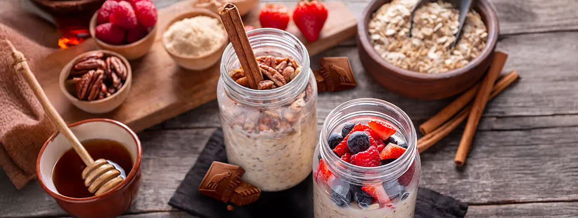 Deux pots d’overnight oats aux fruits rouges et au chocolat Côte d’Or posés sur une table