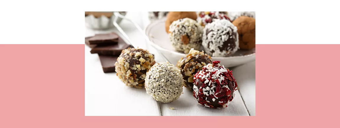 Des boules d’énergie et des morceaux de chocolat posés sur une table et une assiette