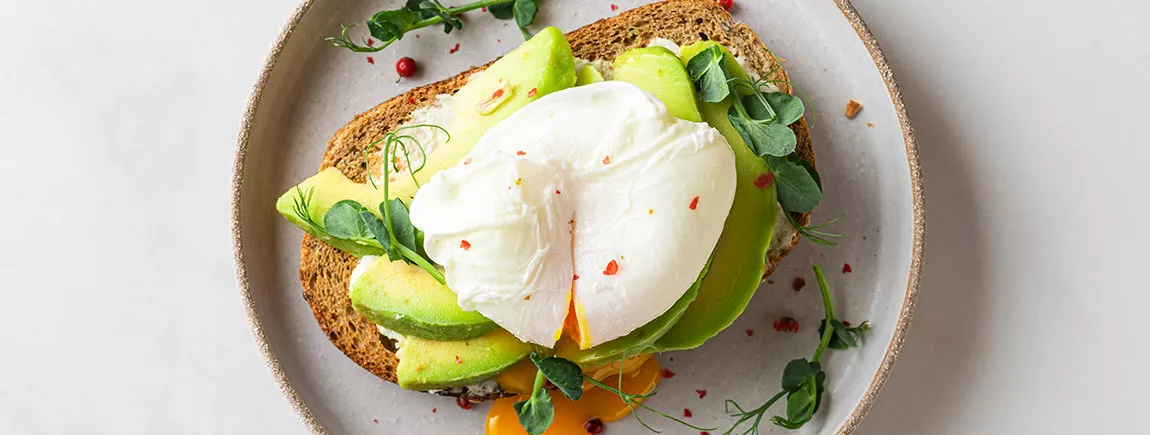Avocado toast* en biscotte, œuf poché, germes de pois et fromage Un avocado toast