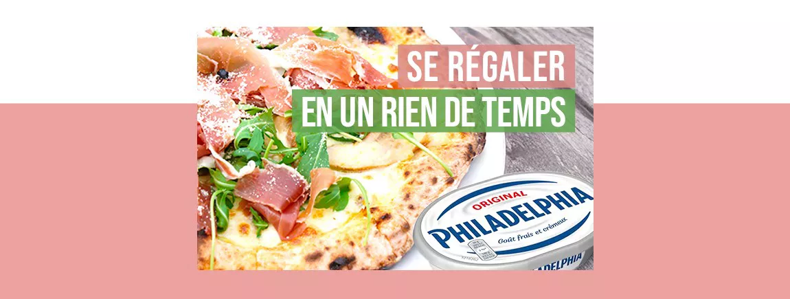 Une pizza à la sauce blanche, jambon et roquette avec un pack de fromage Philadelphia.